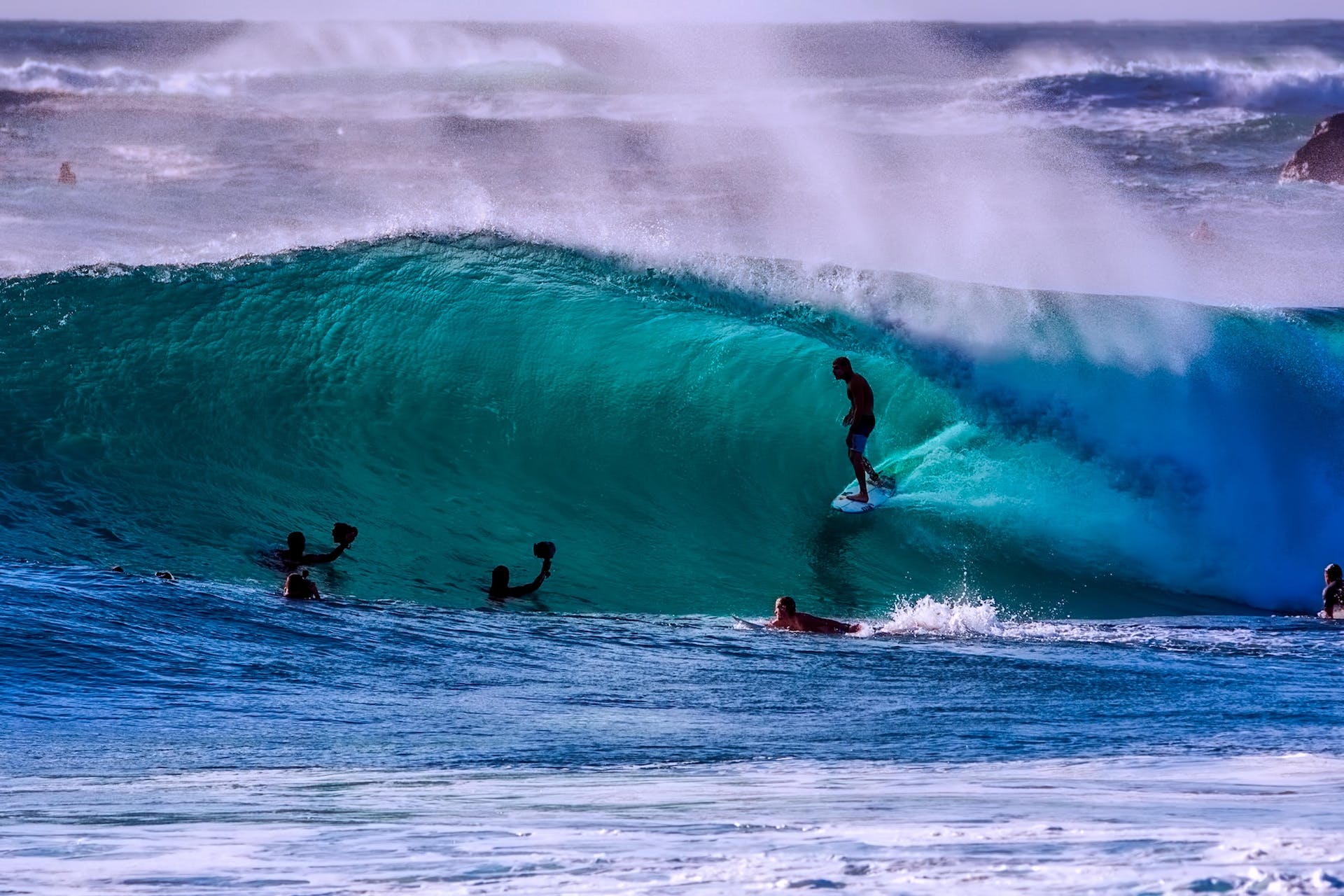 A hero image for the Strive Peptides homepage showing surfers in the waves with lots of blue and green water